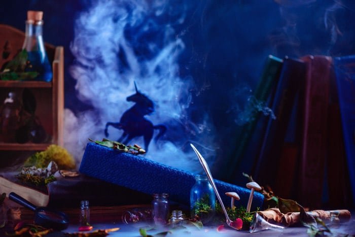 A still life smoke photography featuring glass bottles with the silhouettes of a unicorn and billowing smoke behind