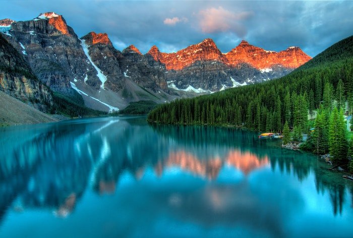 a dramatic photo of a lake surrounded by a mountainous landscape, utilizing dynamic range in photography 
