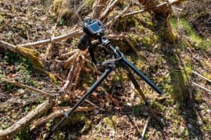 A tripod for macro photography holding a camera and lens in the woods