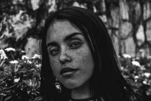 Black and white portrait of a woman with freckles