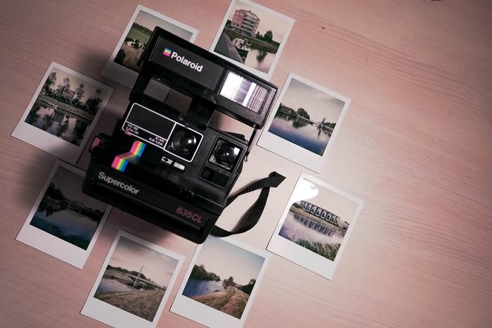 Polaroid camera and polaroid photos on a floor