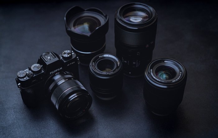 an image of a fujifilm camera and four lenses