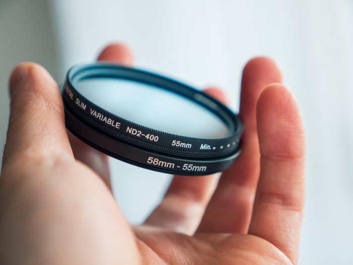 an image of a hand folding a camera lens filter