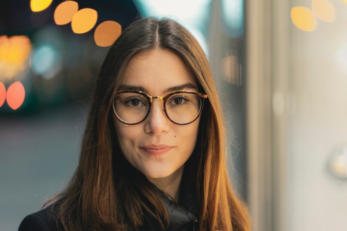 A portrait of a female model in glasses with a blurry bokeh background 