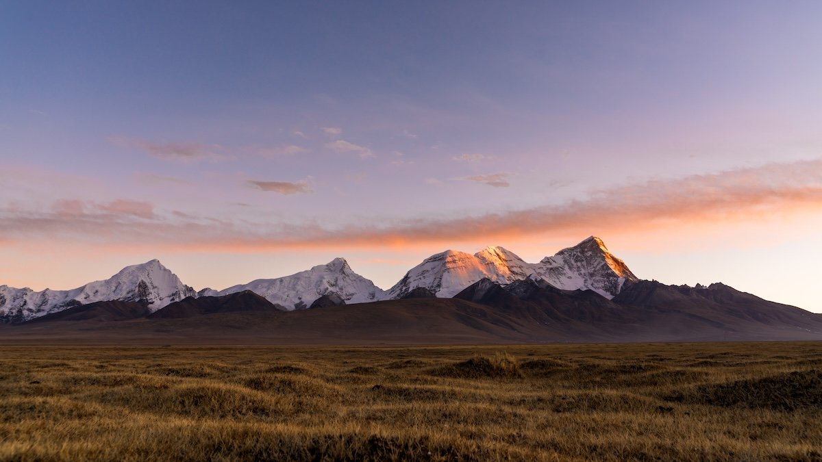 A mountain and meadow landscape at sunset shot with a full-frame camera for high dynamic range
