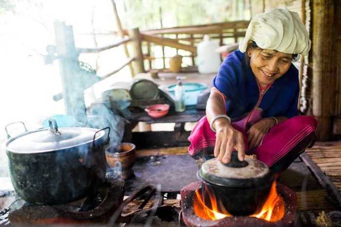 a Karen woman cooking outdoors with incident light falling on the subject 
