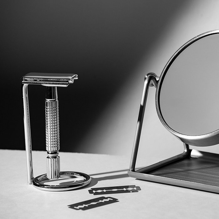 Product styling shot of a razor beside a mirror