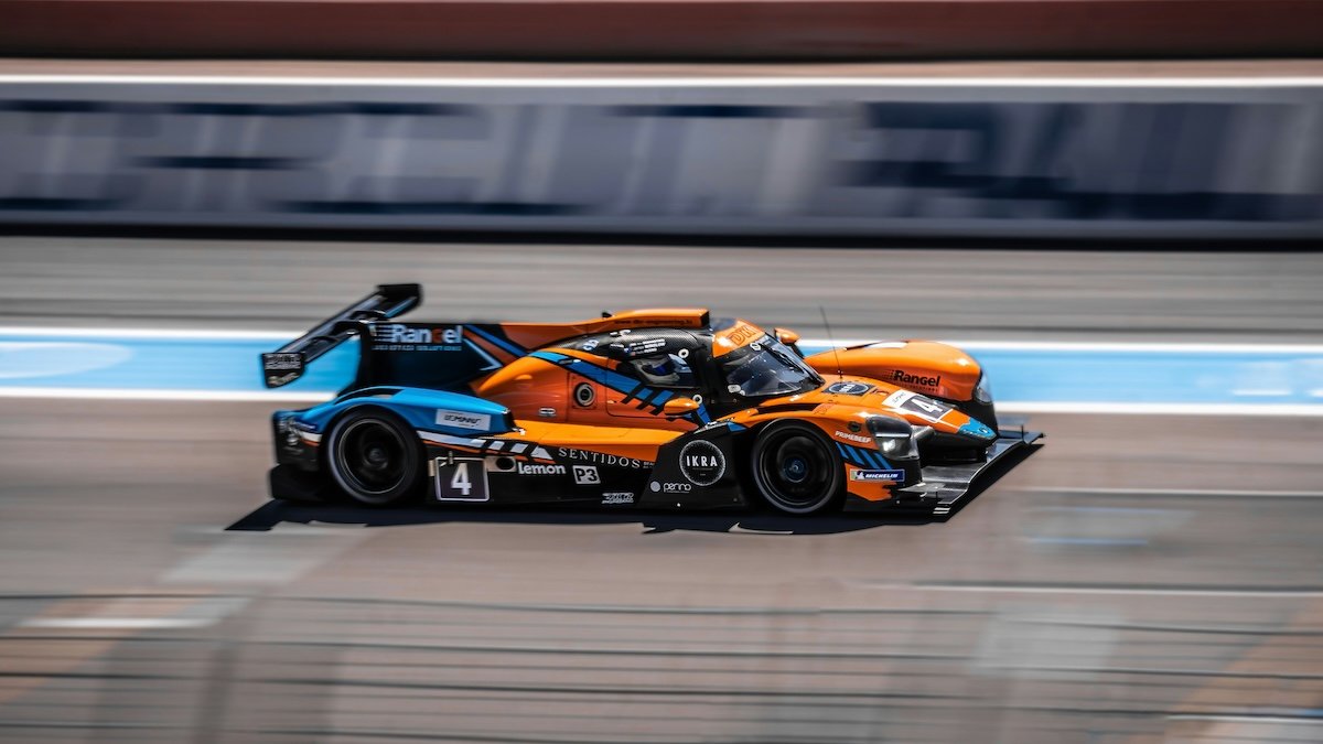 A race car speeding on a track with a blurry background showing motion as an example of sports photography