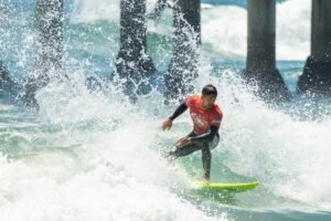 A surfer riding a wave in with water splashing around as an example of surf photography