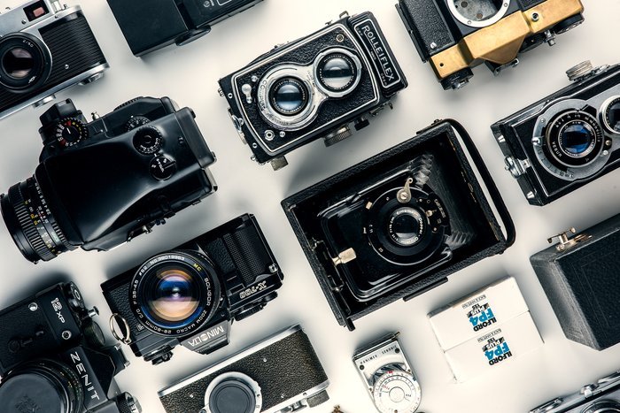 Various cameras laid out on a table 