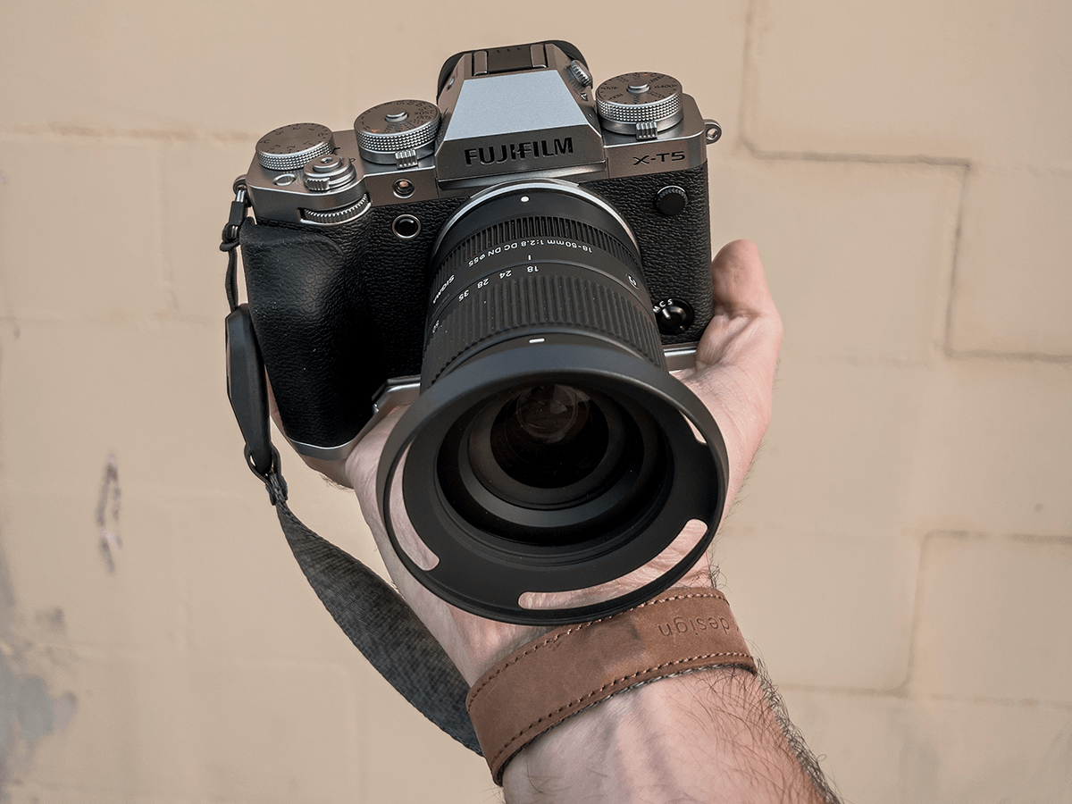 X-T5 Fujifilm camera and lens being held by someone's hand